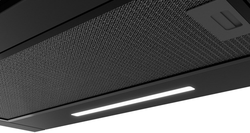 OKAP AKPO WK-7 LIGHT GLASS TOUCH 60 Na zdjęciu widać spód okapu kuchennego z dużym, metalowym filtrem siatkowym i prostokątnym uchwytem do jego wyjmowania. W dolnej części kadru znajduje się wąska, podłużna listwa LED, zapewniająca równomierne oświetlenie płyty grzewczej.