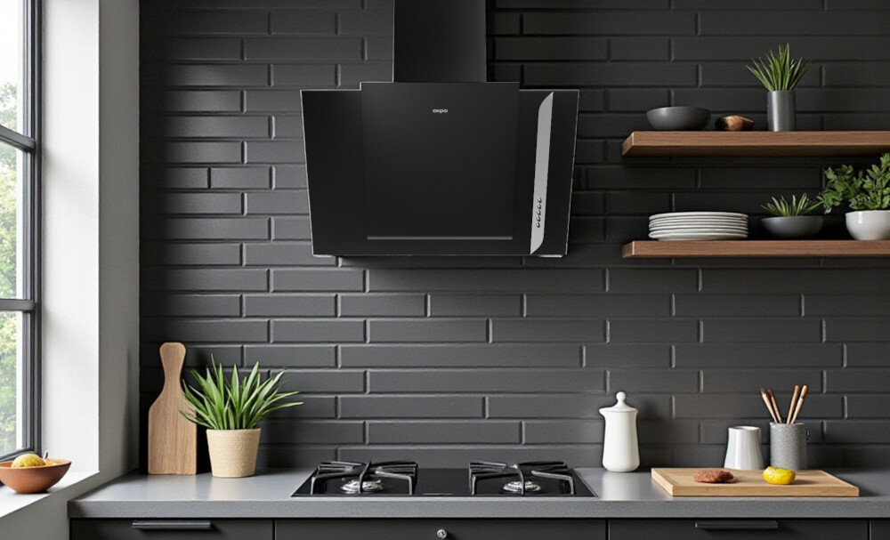 OKAP AKPO WK-4 Grand 50 Na zdjęciu 22.jpg widać jasną kuchnię z czarnym, szklanym okapem skośnym zamontowanym nad gazową płytą grzejną z czterema palnikami. Blat zdobi doniczka z rośliną oraz deski do krojenia i owoce, co podkreśla minimalistyczny, elegancki wystrój wnętrza