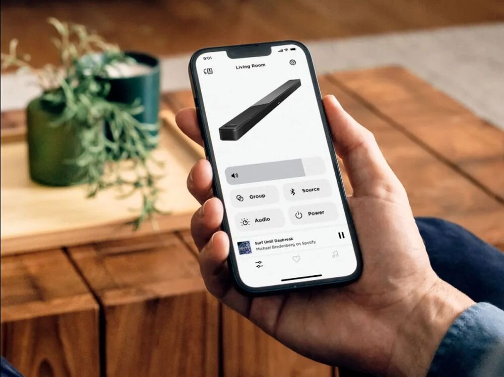 Soundbar BOSE Smart Ultra aplikacja Bose Music Wi-Fi SimpleSync ADAPTiQ, smartfon trzymany w ręku