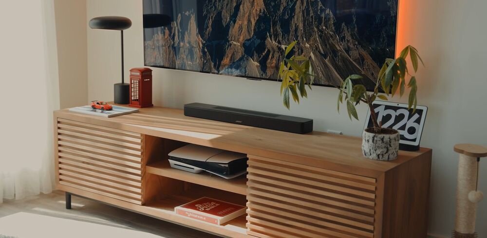 Soundbar BOSE Smart kinowe brzmienie dźwięk przestrzenny, soundbar stojący na komodzie w pomieszczeniu