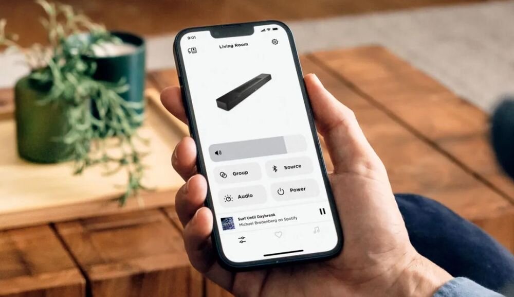 Soundbar BOSE Smart aplikacja Bose Wi-Fi SimpleSync regulacja dźwięku Dialogue AI, smartfon trzymany w ręku