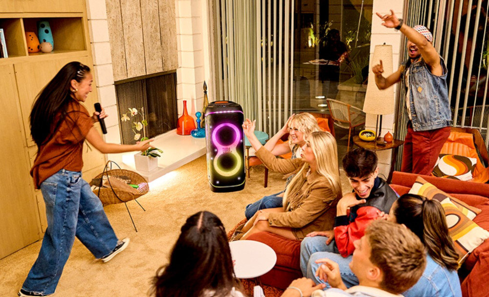 Power audio JBL PartyBox 720 moc 800W Pro Sound głębokie basy czysta góra, power audio stojące w pomieszczeniu na podłodze, osoby bawiące się w rytm muzyki