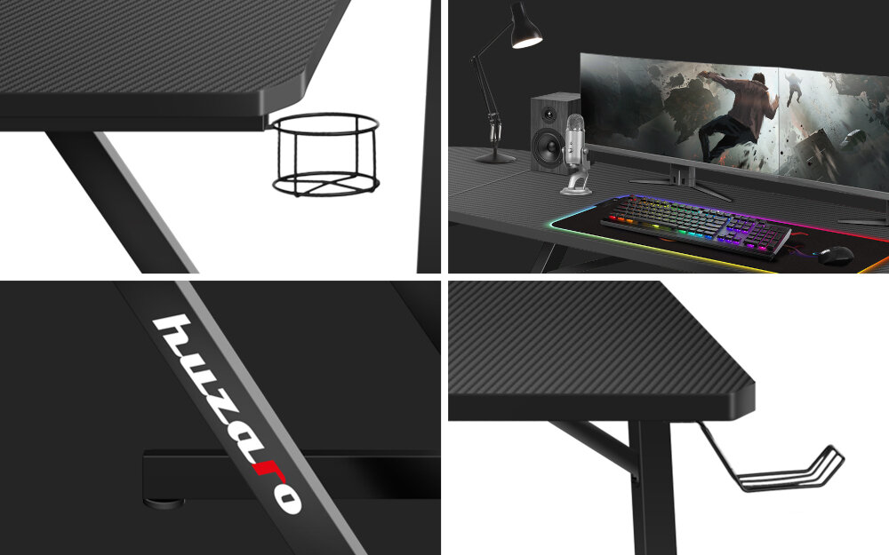 Obraz przedstawia czarne biurko gamingowe z teksturą, wyposażone w uchwyt na kubek i słuchawki. Na biurku znajduje się monitor, klawiatura z podświetleniem RGB, głośniki i lampa; widoczne jest logo \'huzaro\'.