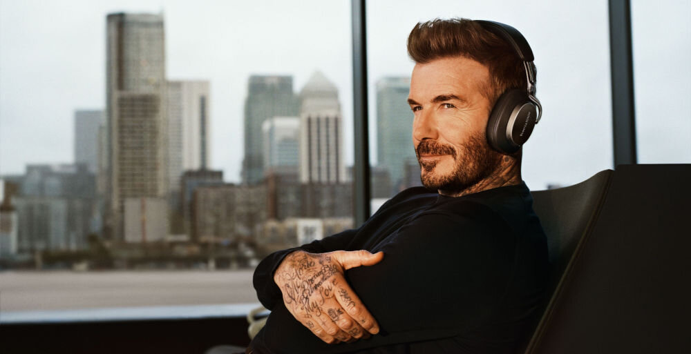 Słuchawki nauszne BOWERS & WILKINS Px8 S2 ANC aptX Lossless aptX Adaptive streaming bezstratny Spotify Tidal Amazon Music, David Beckham z założonymi słuchawkami nausznymi