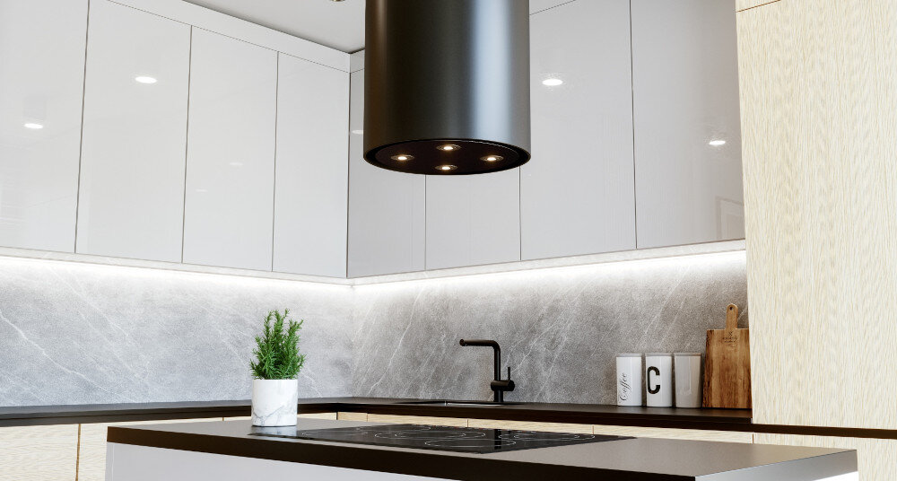 OKAP GLOBALO CYLINDRO ISOLA 39.7 BLACK Zdjęcie przedstawia kuchnię z wyspą wyposażoną w płytę grzewczą. Nad wyspą zamontowany jest okap w kształcie czarnej tuby z czterema wbudowanymi lampkami LED. W centralnym miejscu na wyspie stoi roślina w doniczce, a w tle widać eleganckie, połyskujące szafki oraz detale kuchenne. Całość utrzymana jest w jasnej, minimalistycznej aranżacji z kontrastowym czarnym akcentem wyspowy globalo czarny stal szlachetna tuba kuchenny sufitowy design premium wyspa cylindryczny elegancki kuchnia agd wydajny dekoracyjny