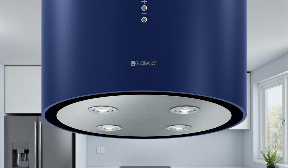 OKAP GLOBALO CYLINDRO ISOLA 39.7 BLUE Zdjęcie przedstawia okap kuchenny w kształcie niebieskiej tuby firmy Globalo, widziany od dołu. Na spodzie urządzenia znajdują się cztery wbudowane lampki LED rozmieszczone symetrycznie. W tle widoczne są elementy kuchni: zlew, rośliny w doniczkach, drewniane deski oraz piekarnik. Kompozycja podkreśla elegancki wygląd, solidne wykonanie i funkcjonalne oświetlenie okapu światło power led 4200k regulacja barwy światła 2900k 6300k oświetlenie kuchenne dopasowanie nastroju okap oświetlenie robocze oświetlenie