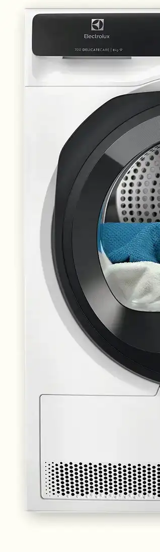 Fragment suszarki z widocznym okrągłym bębnem, w którym znajdują się kolorowe tkaniny. Na panelu widoczny jest napis \'Electrolux 700 DELICATECARE 8 kg\'.