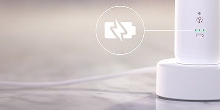 Szczoteczka podłaczona do ładowarki. Zbliżenie na ikonę baterii.