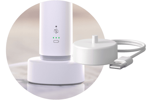 Szczoteczka umieszczona w podstawce ładującej. Obok znajduje się podstawka ładująca.