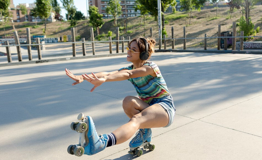 Słuchawki JBL Tune 530BT Pure Bass przetworniki 33 mm dynamiczny dźwięk, osoba jeżdżąca na rolka w słuchawkach nausznych