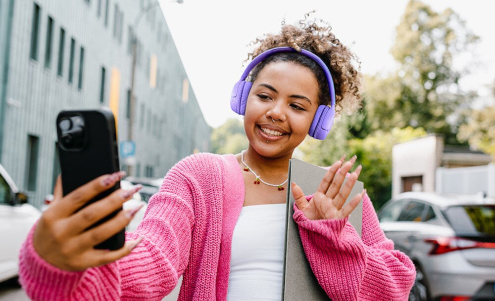 Słuchawki JBL Tune 530BT Bluetooth 76 h USB-C szybkie ładowanie, osoba prowadząca wideorozmowę mająca założone słuchawki nauszne