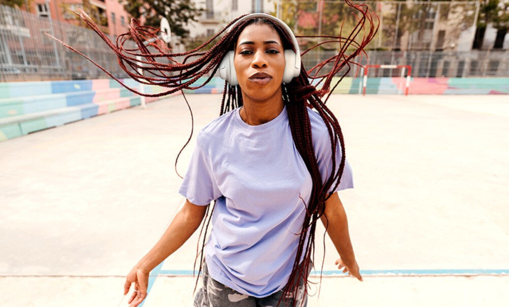 Słuchawki JBL Tune 730BT - Brzmienie, które inspiruje, osoba z założonymi słuchawkami nausznymi na boisku wielofunkcyjnym