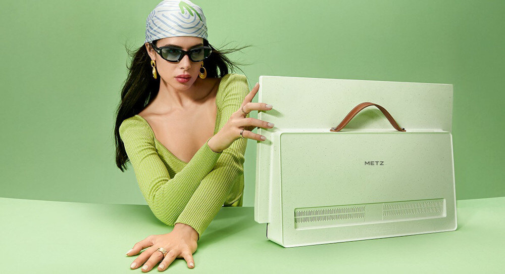 Telewizor METZ 24MPE7200Z przenośny ekran LED 24 cale Full HD wygoda mobilna, telewizor stojący na blacie, kobieta trzymająca go ręką