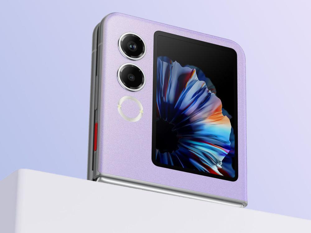 Smartfon NUBIA Flip 2 5G 8/256GB 6.9 120Hz Czarny sztuczna inteligencja AI tłumaczenie tekst muzyka asystent konwersacji - Złożony smartfon Nubia Flip w kolorze lawendowym (fioletowym), stojący na białej krawędzi, na jasnym, niebiesko-fioletowym tle. Widoczny jest zewnętrzny ekran z abstrakcyjną, kolorową tapetą, dwa obiektywy aparatu oraz jasny okrągły element obok nich.