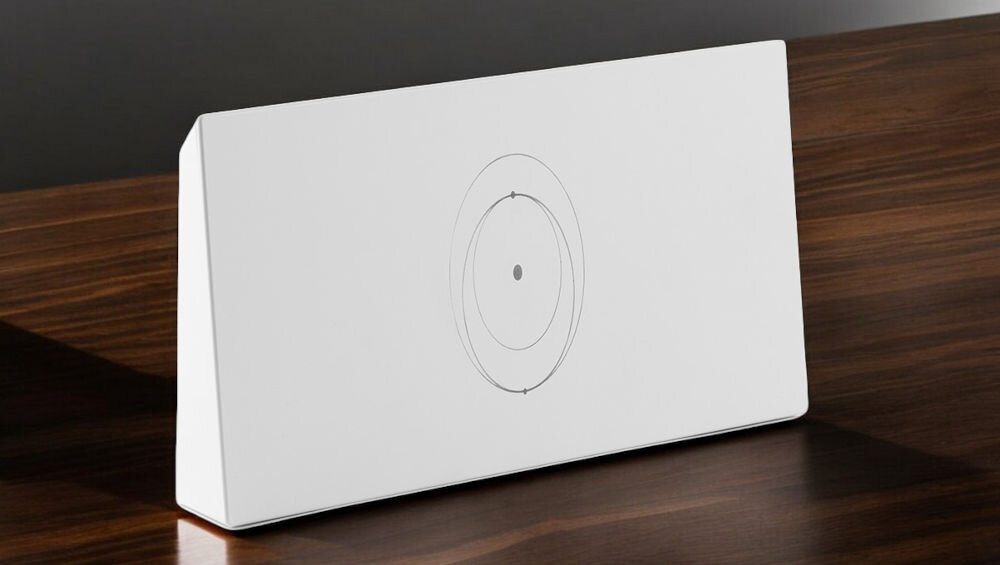 Na drewnianym blacie stoi biały, prostokątny router z delikatnym wzorem okręgów na przedniej stronie. Urządzenie ma minimalistyczny design i brak widocznych przycisków lub portów.