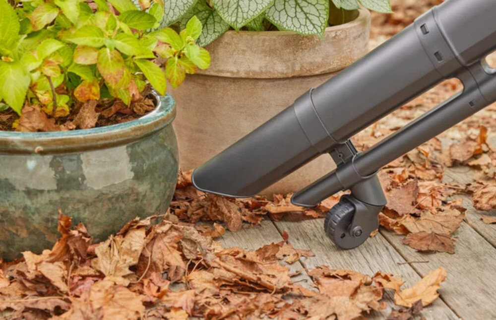Dmuchawa do liści akumulatorowa GARDENA 18V P4A 14895-55 taras drewniana podłoga donice z kwiatami liście osoba odkurza liście zbliżenie na rurę i koło przepływ powietrza o prędkości do 352 km/h wytrzymały metalowy wirnik tryb PowerBoost