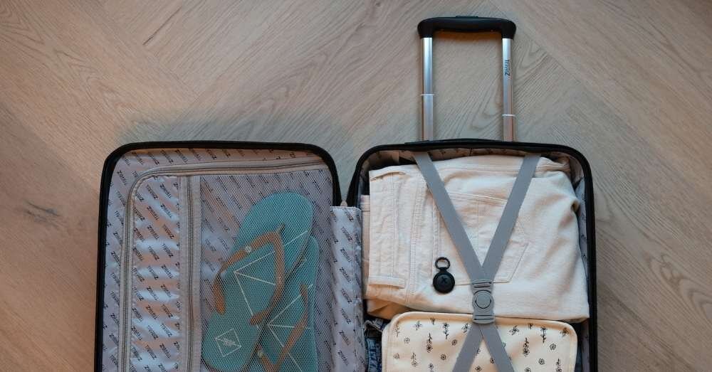 Lokalizator XTORM TravelTag XTAG2GA11 Czarny (3 szt.), spryt, ochrona, lokalizacja, strażnik, Lokalizator Xtorm przypięty do spodni w otwartej walizce.