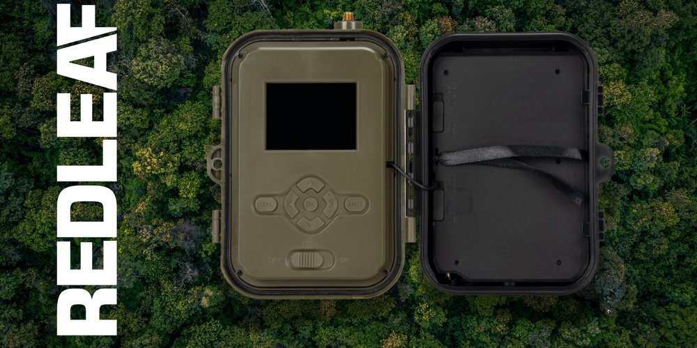 Obraz przedstawia otwartą fotopułapkę na tle lasu. Po lewej stronie widoczny jest napis \'REDLEAF\'.