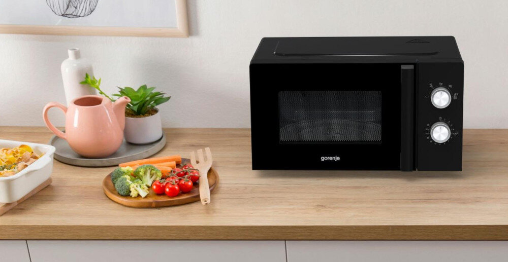 KUCHNIA MIKROFALOWA GORENJE MO17E1BH lifestyle kuchnia blat akcesoria kuchenne warzywa na talerzu kuchenka front czarna zamknięta