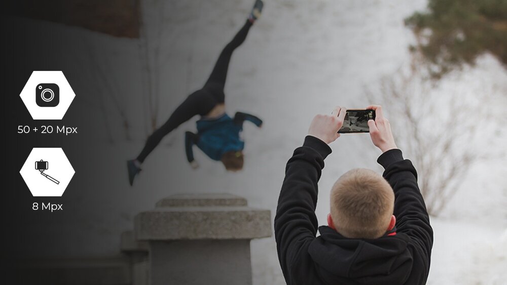 HAMMER ENERGY X2  mężczyzna robi zdjęcie akrobaty zimą; oznaczenia aparatów: 50 + 20 Mpx tył oraz 8 Mpx kamera przednia.