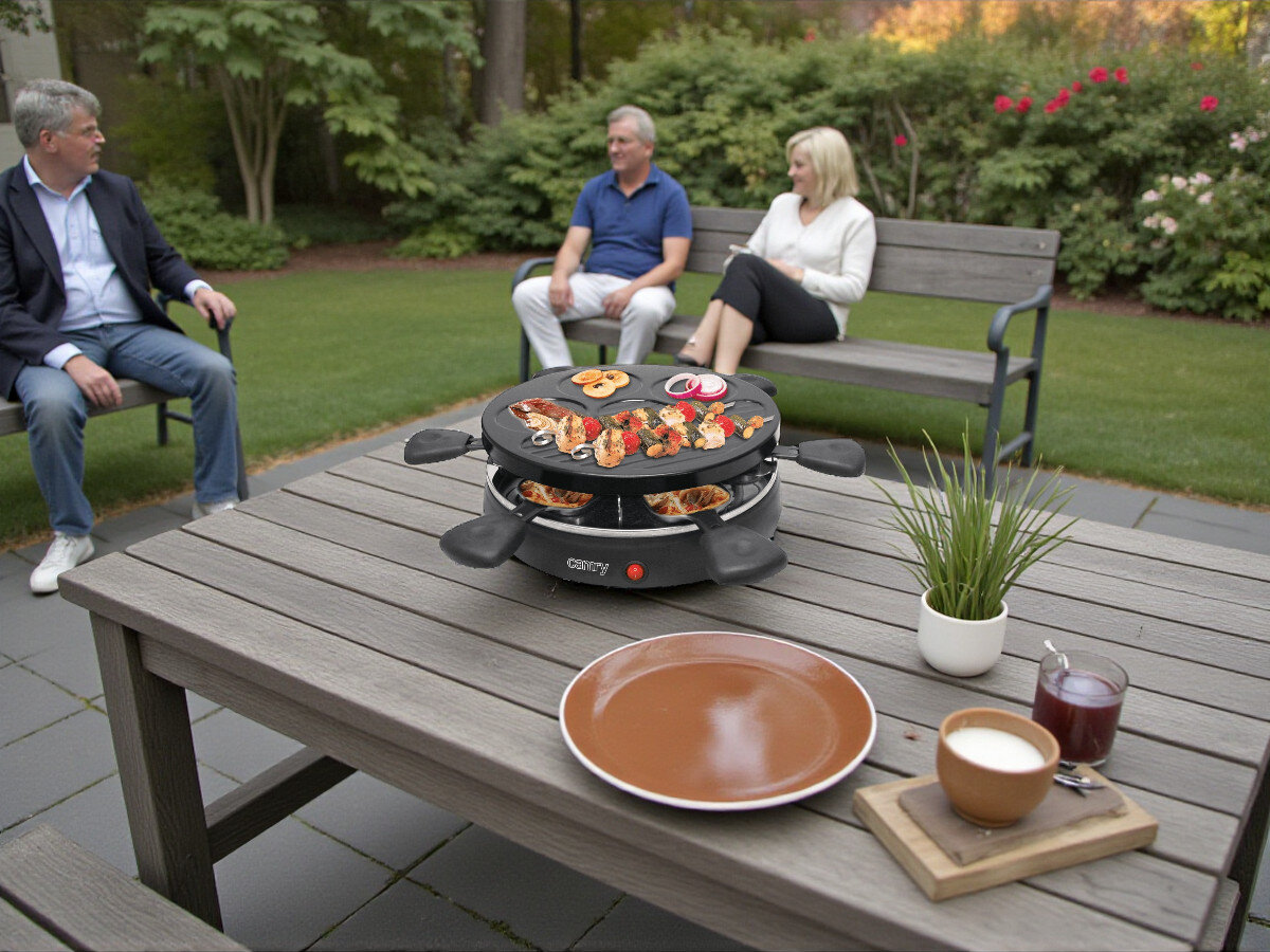 Grill elektryczny CAMRY CR 6606, stabilność, stół, stopki, wygoda, Raclette z grillowanymi przekąskami na tarasie ogrodowym
