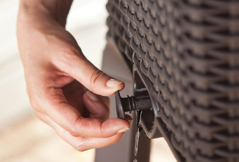 Donica KETER Easy Grow 230298 120 L Antracytowy dłoń osoby osoba odkręca kranik widoczna woda wypływająca z donicy praktyczny kranik w dolnej części donicy zybkie usunięcie nadmiaru wody korzenie roślin nie są narażone na przemoczenie