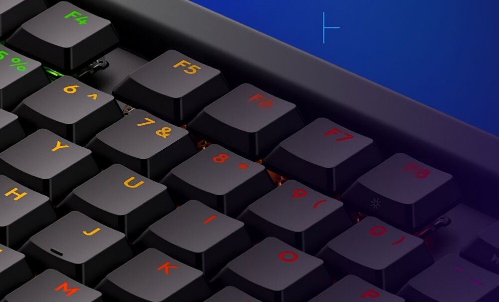 Zbliżenie na klawiaturę z czarnymi klawiszami, na których widoczne są kolorowe oznaczenia liter i cyfr. Klawisze funkcyjne F4 do F8 mają różne kolory oznaczeń.