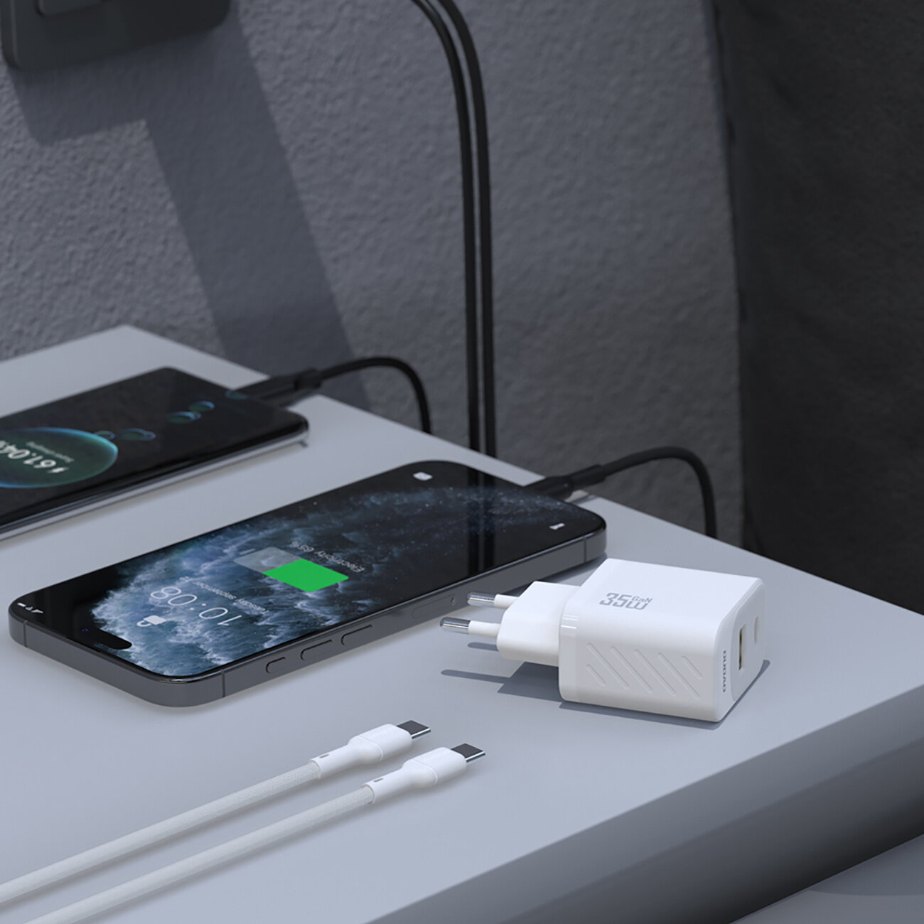 Na obrazie widać białą ładowarkę sieciową z napisem \'35W\' oraz dwa smartfony podłączone do niej za pomocą kabli USB-C. Jeden z telefonów pokazuje ekran ładowania z poziomem baterii 80%.