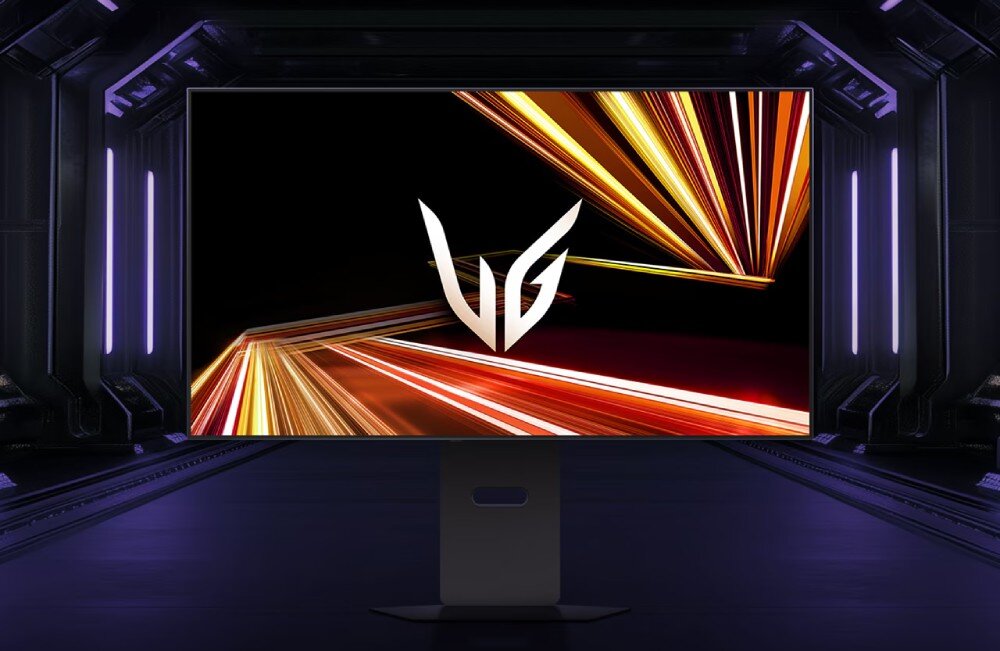 Monitor LG UltraGear 32GX870A-B Frontowy widok monitora na ciemnym tle, wyświetlającego na środku białe logo 'UG' otoczone dynamicznymi smugami pomarańczowego i czerwonego światła