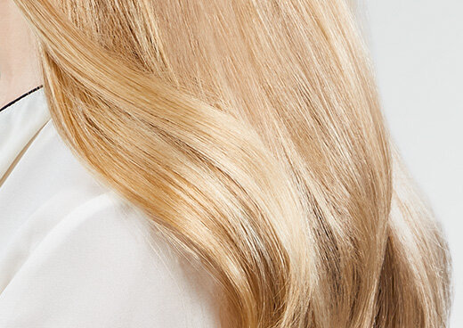 Zbliżenie na blond pasma włosów kobiety.