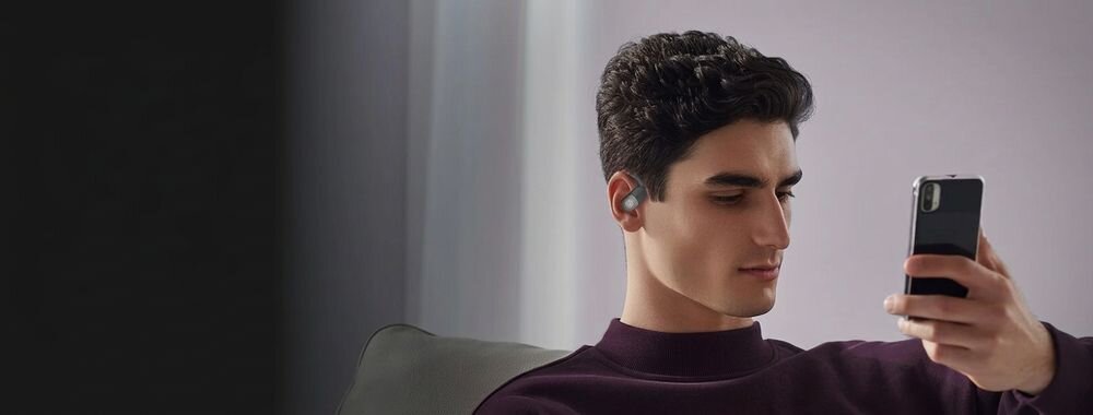 BUGANI Free B15 mikrofony MEMS ENC redukcja szumów wyraźne rozmowy, osoba z założonymi słuchawkami z telefonem w ręku