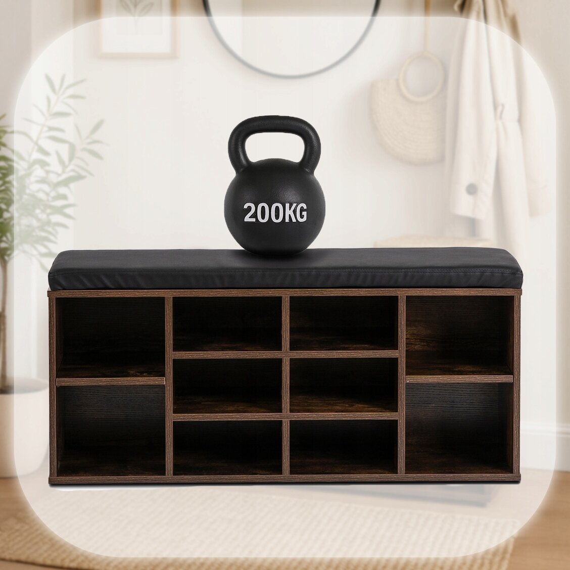 Szafka na buty z siedziskiem w kolorze dąb rustykalny, z czarną poduszką na górze. Na siedzisku znajduje się czarny kettlebell z napisem \'200KG\'.