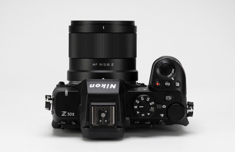 Aparat fotograficzny z zamontowanym obiektywem, na którym widnieje napis \'AF 9/2.8 Z\'. Na korpusie aparatu widoczne są napisy \'Nikon\' i \'Z 50 II\'.