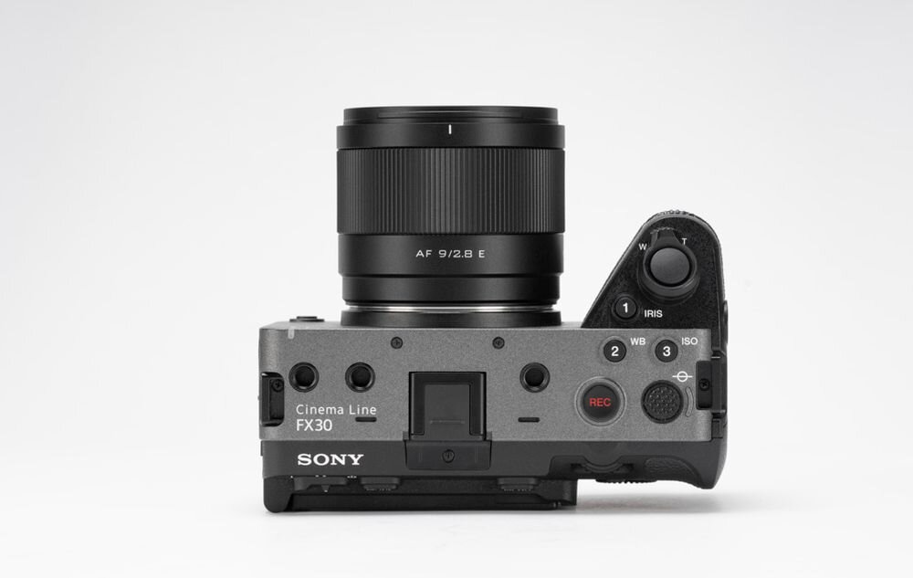 Aparat fotograficzny z obiektywem, na którym widnieje napis \'AF 9/2.8 E\'. Na korpusie aparatu znajduje się napis \'Cinema Line FX30\' oraz logo \'SONY\'.