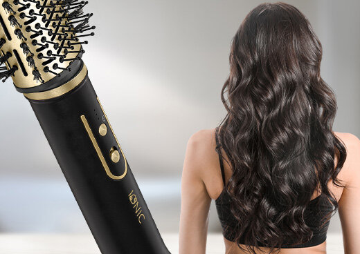 Zbliżenie na przyciski suszarko-lokówki. Obok zwrócona tyłem kobieta z długimi włosami.