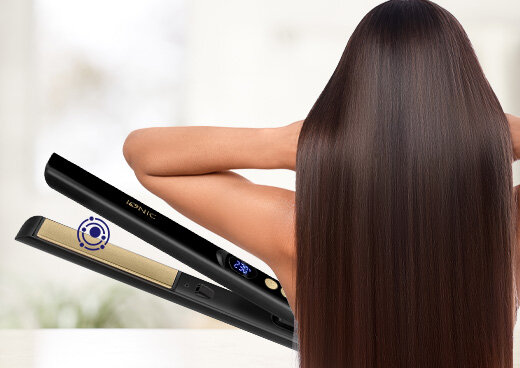 Prostownica z uproszczonym symbolem jonizacji. Obok zwrócona tyłem kobieta z długimi włosami.