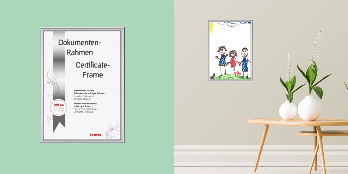 Srebrna, aluminiowa ramka na dokumenty w formacie DIN A4 firmy Hama. Ramka zawiera grafikę informującą, że służy do prezentowania dokumentów, dyplomów i certyfikatów. Po prawej stronie widoczny jest pokój, w którym na ścianie wisi mniejsza, srebrna ramka z dziecięcym rysunkiem, postawiona na drewnianym stoliku obok dwóch białych wazonów z kwiatami.