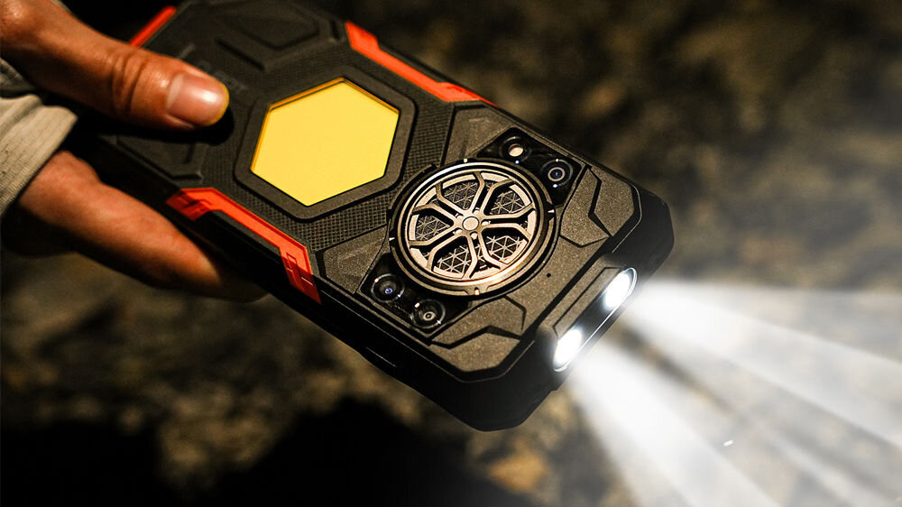 Smartfon CUBOT KING KONG Power 5 16/128GB 6.88 120Hz Czarny Zbliżenie na tylną część smartfona Cubot trzymanego w ręce, z włączoną jasną, podwójną latarką, która świeci intensywnym strumieniem światła w ciemne otoczenie