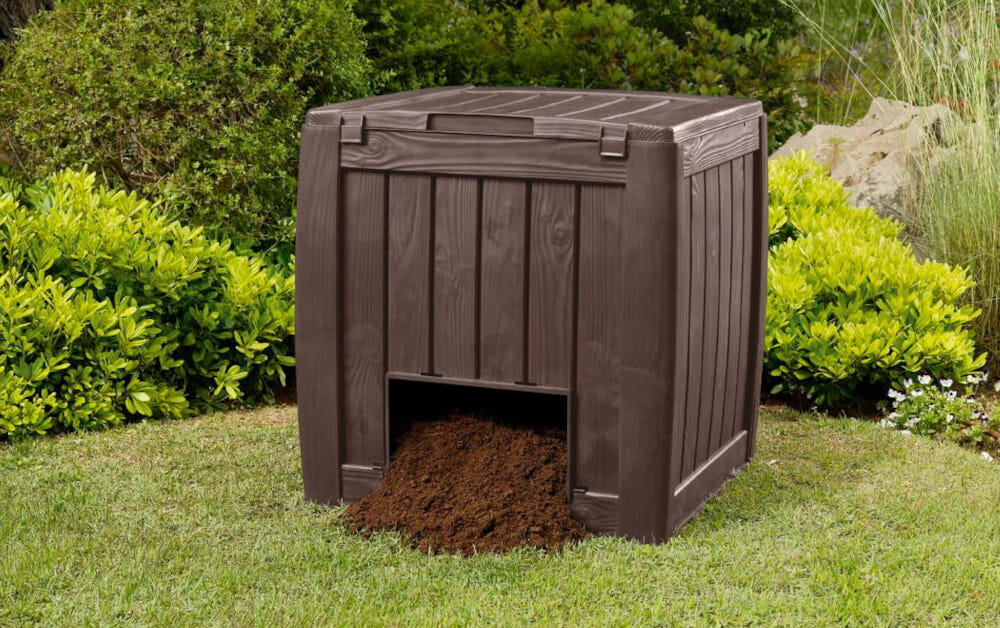 Kompostownik KETER Deco Composter 340L Brązowy kompostownik na trawie na tle krzewów system JUST CLIC&GO szybkie i intuicyjne złożenie kompostownika bez użycia narzędzi solidna konstrukcja stabilność precyzyjne łączenia szczelność