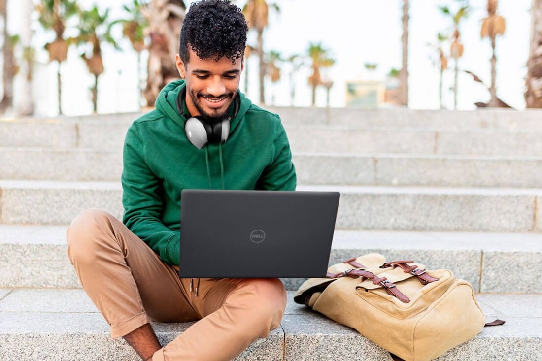Mężczyzna na schodach pracuje na laptopie DELL Inspiron 3530. - Szybka łączność Wi-Fi 6