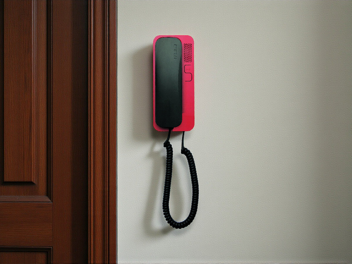 Unifon CYFRAL Smart-D Czarno-czerwony, bezpieczeństwo, rozmowa, regulacja, sekretność, Unifon CYFRAL Smart-D czarno-czerwony w białym korytarzu, widok na salon z kanapą i rośliną.