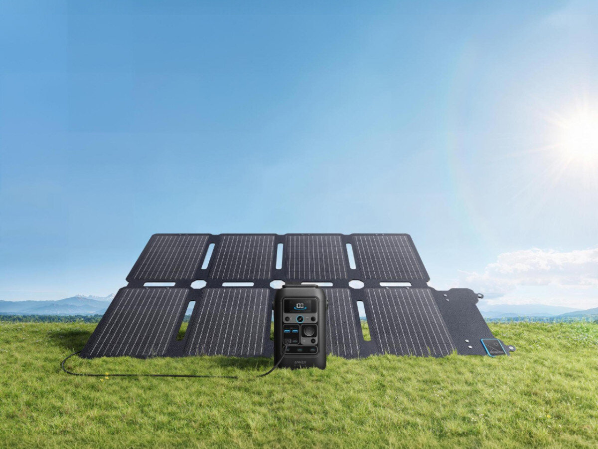 Stacja zasilania ANKER Solix C300X DC 288WH Bank energii + Panel solarny PS60 60W, wyświetlacz, lampa, LED, oświetlenie, słoneczny dzień na trawniku stoją panele wraz ze stacją zasilania