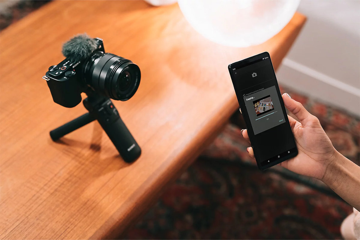 SONY ZV-E10LBD 16–50 mm OSS II napędem zoomu zdjęć i filmów szerokie kadry, portrety i codzienne chwile optycznej stabilizacji obrazu, cichej pracy autofokusa i składanej konstrukcji  ZV-E10 70 obiektywami z mocowaniem Sony E - Aparat fotograficzny na statywie połączony ze smartfonem przesyłającym zdjęcia przez aplikację