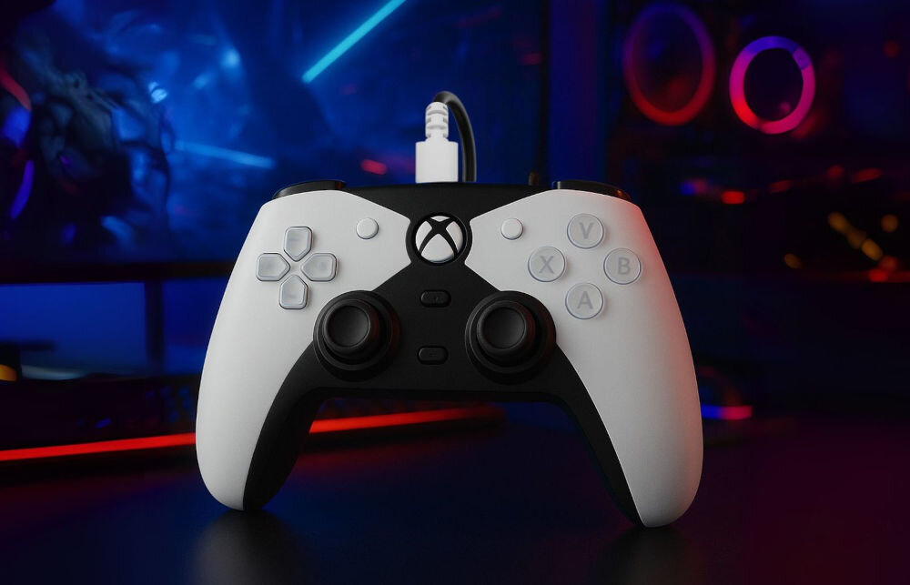 Kontroler HYPERKIN Competitor M01638-WH Biały prezentacja pada z podłączonym kablem na ciemnym biurku w tle monitor komputer i podświetlenia