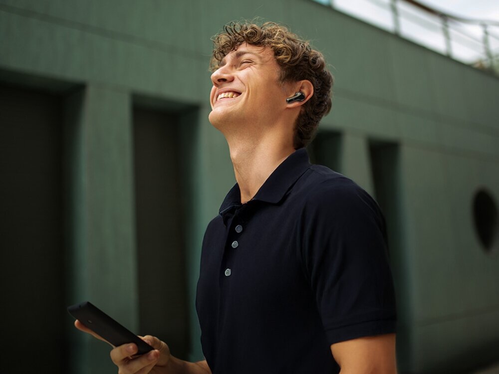 Słuchawki dokanałowe CREATIVE Aurvana Ace SXFI z hybrydową redukcją szumów ANC i trybem Ambient, osoba z założonymi słuchawkami