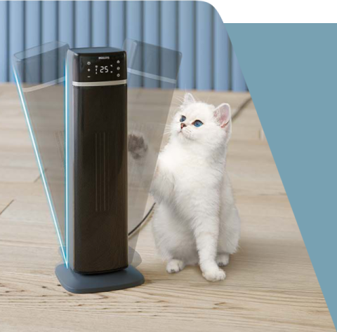 Na drewnianej podłodze stoi termowentylator z wyświetlaczem pokazującym \'25°\', obok którego znajduje się biały kot. Na urządzeniu widoczne jest logo \'PHILIPS\'.