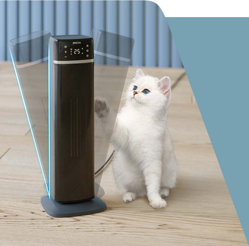 Na drewnianej podłodze stoi termowentylator z wyświetlaczem pokazującym \'25°\', obok którego znajduje się biały kot. Na urządzeniu widoczne jest logo \'PHILIPS\'.