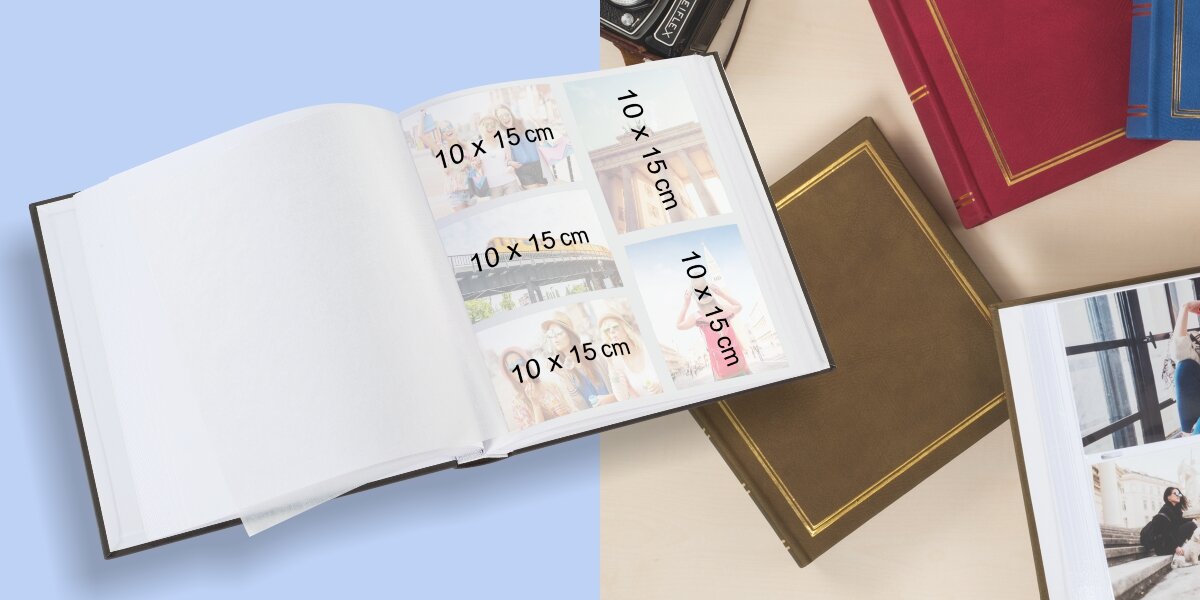 Na obrazie widoczny jest otwarty album fotograficzny z białymi kartkami, na których umieszczono zdjęcia o wymiarach 10 x 15 cm. Obok znajdują się zamknięte albumy w różnych kolorach z ozdobnymi złotymi liniami na okładkach.
