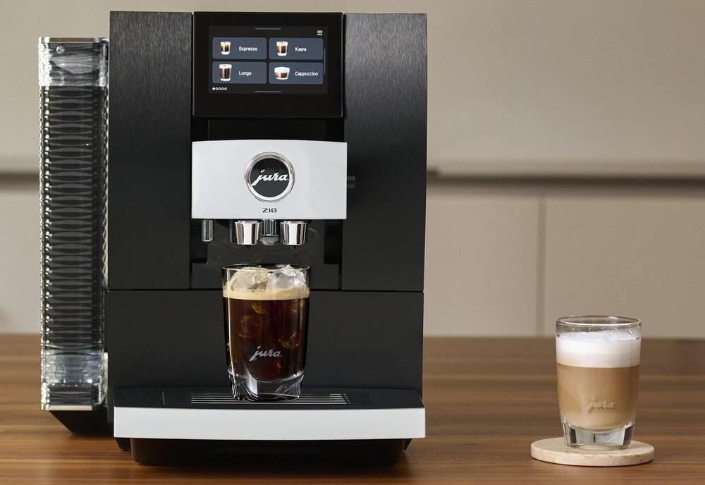 Ekspres Jura Z10 na drewnianym blacie z przygotowaną czarną kawą mrożoną w szklance oraz kawą latte stojącą obok