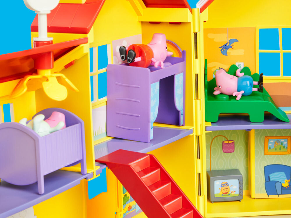 Zestaw figurek HASBRO Świnka Peppa Duży dom rodzinny Peppy G05085L0 Wnętrze zabawkowego domku Peppa Pig pokazujące piętro z sypialniami. Figurka Peppy leży na fioletowym łóżku piętrowym, a George odpoczywa na zielonym łóżku w kształcie dinozaura. Na dole widoczne są czerwone schody prowadzące na parter oraz miniaturowy telewizor.